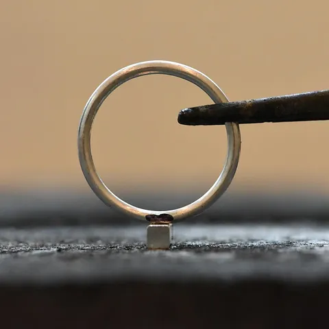 Here is a tip I shared in my book, you can find it in the Stacking Rings Project - I use a miter jig to file a small flat...